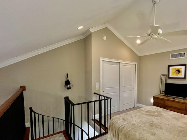 bedroom with visible vents, ceiling fan, vaulted ceiling, crown molding, and a closet