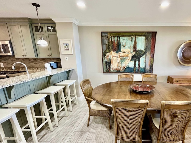 dining space with ornamental molding and baseboards