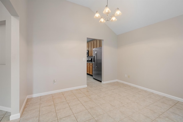 tiled spare room with an inviting chandelier and high vaulted ceiling