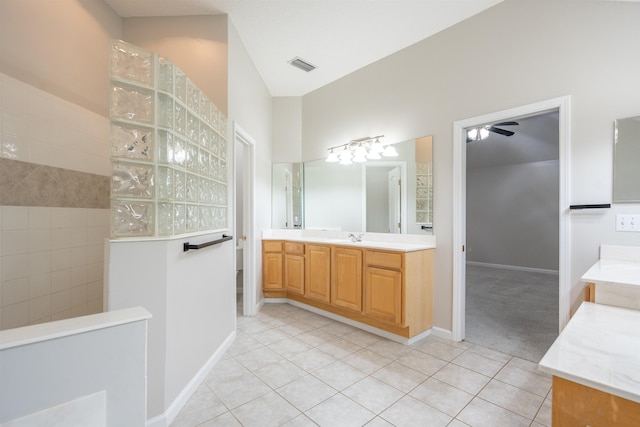 bathroom featuring tile patterned floors, vanity, ceiling fan, and a tile shower