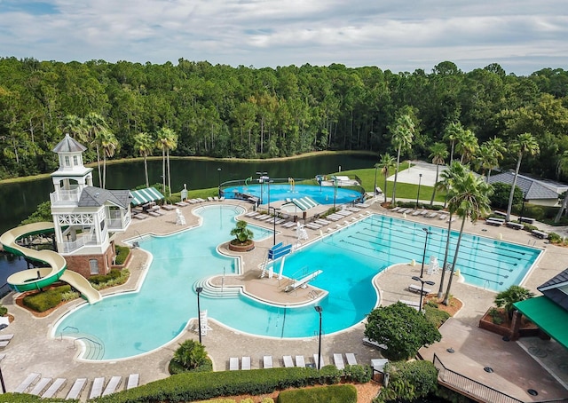 view of swimming pool with a water view, a patio area, and a water slide