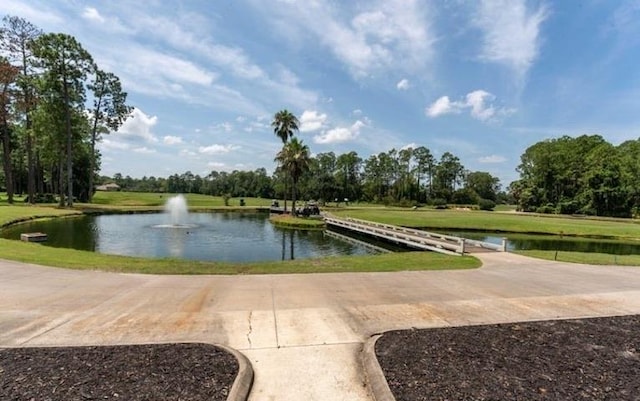 view of property's community featuring a lawn and a water view