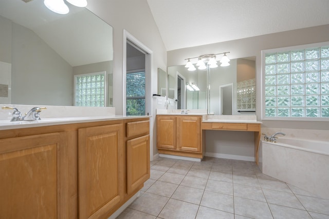 bathroom with tile patterned floors, a washtub, vanity, and vaulted ceiling