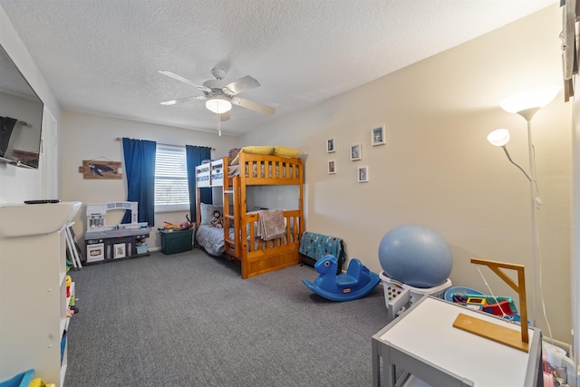 bedroom featuring ceiling fan, a textured ceiling, and dark colored carpet