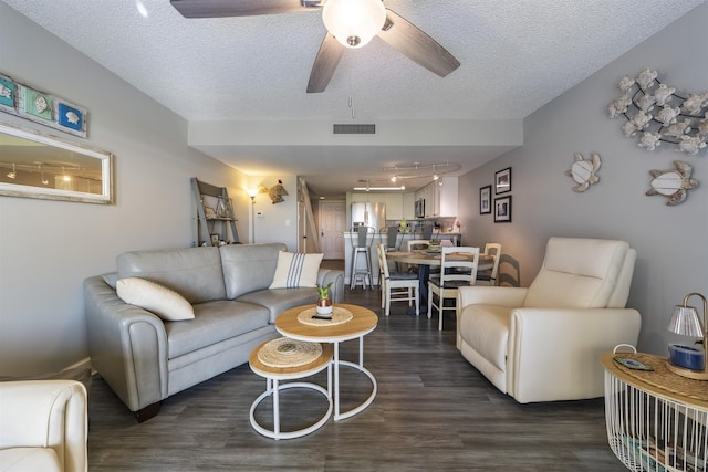 living room featuring ceiling fan, dark hardwood / wood-style floors, and a textured ceiling