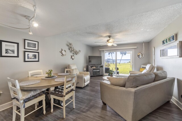 dining space with a textured ceiling, ceiling fan, and dark wood-type flooring