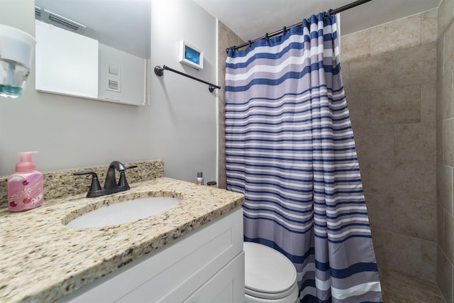 bathroom featuring a shower with curtain, vanity, and toilet