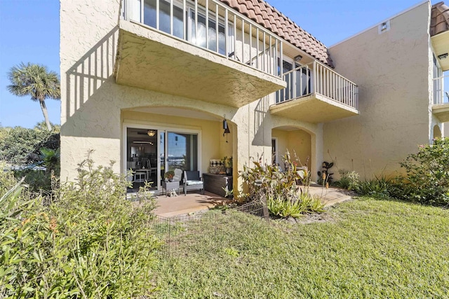 back of house featuring a balcony, a yard, and a patio