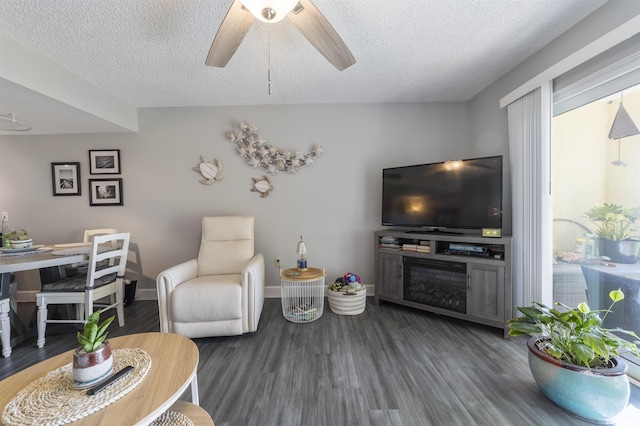 living room featuring ceiling fan, dark hardwood / wood-style flooring, and a textured ceiling