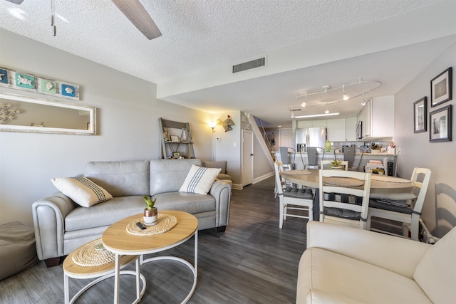 living room featuring a textured ceiling and dark wood-type flooring