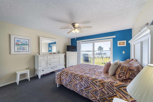 carpeted bedroom featuring ceiling fan and a textured ceiling