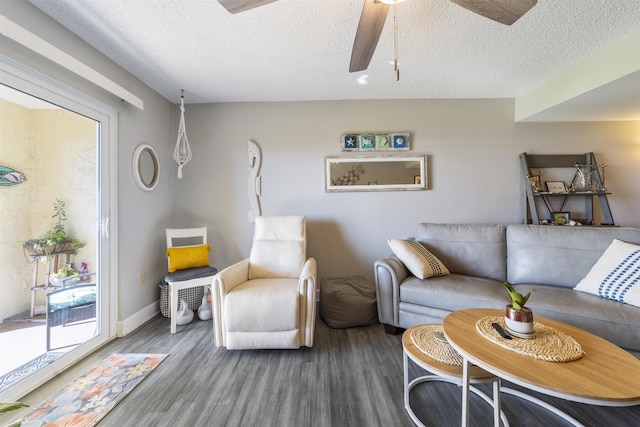 living room featuring ceiling fan, wood-type flooring, and a textured ceiling