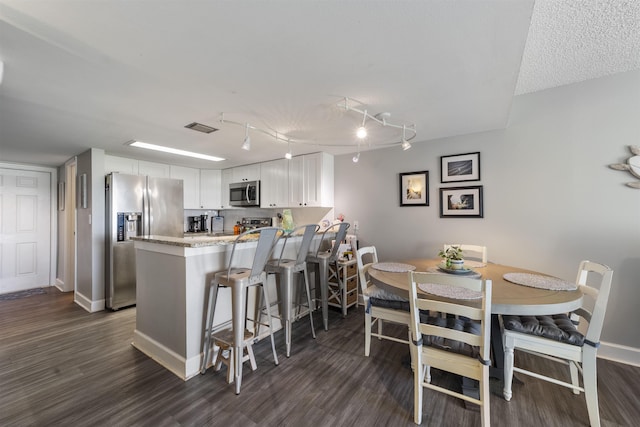 kitchen featuring kitchen peninsula, white cabinetry, dark hardwood / wood-style floors, and appliances with stainless steel finishes