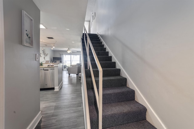 stairway with hardwood / wood-style floors and ceiling fan