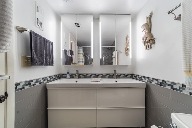 bathroom featuring a shower with curtain, vanity, toilet, and tile walls