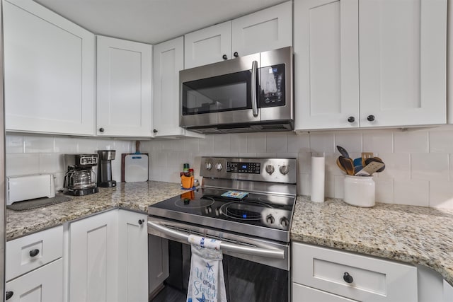 kitchen featuring backsplash, light stone counters, white cabinets, and appliances with stainless steel finishes