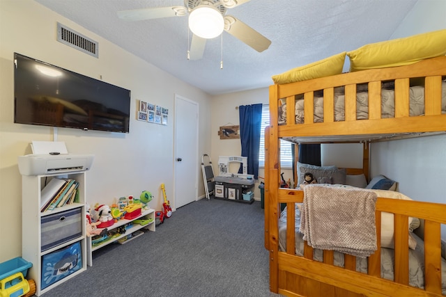 carpeted bedroom with ceiling fan and a textured ceiling