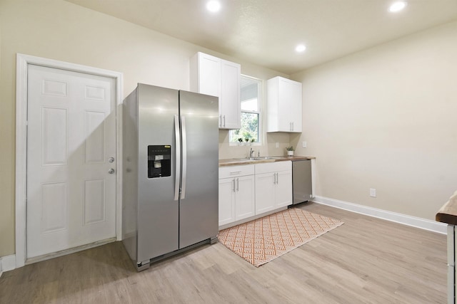 641 W Cathedral, Saint Augustine, FL 32084 - kitchen with white cabinets, light wood-style floors, appliances with stainless steel finishes, and a sink