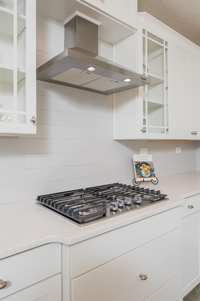 98 Windermere Way, Saint Augustine, FL 32095 - kitchen featuring wall chimney range hood, stainless steel gas cooktop, white cabinets, and tasteful backsplash