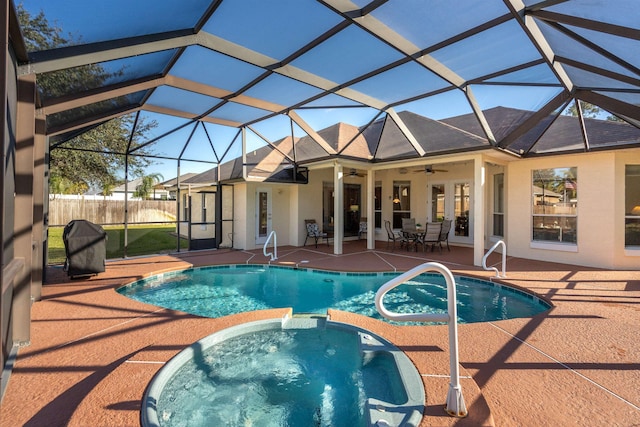 view of pool featuring an in ground hot tub, ceiling fan, a patio, and glass enclosure