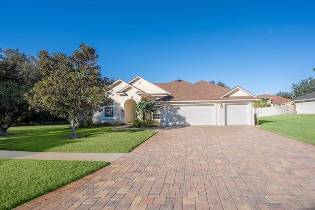 single story home featuring a garage and a front lawn