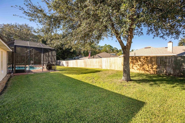 view of yard with a lanai and a fenced in pool