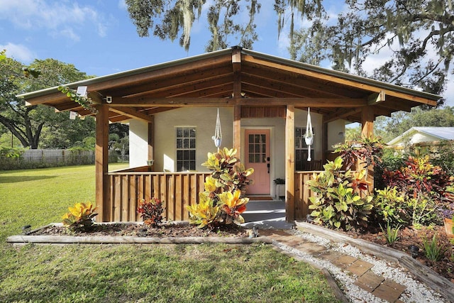 view of front of property featuring a front lawn, fence, and stucco siding