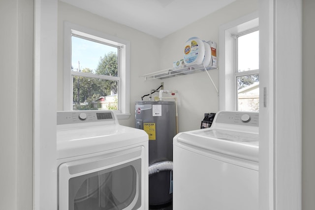 clothes washing area featuring water heater and independent washer and dryer