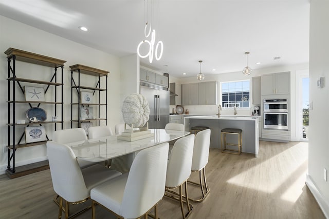 dining space with light hardwood / wood-style floors and sink