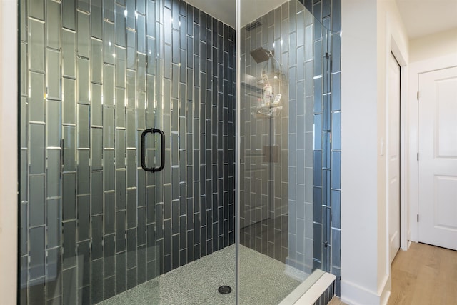 bathroom featuring an enclosed shower and hardwood / wood-style flooring