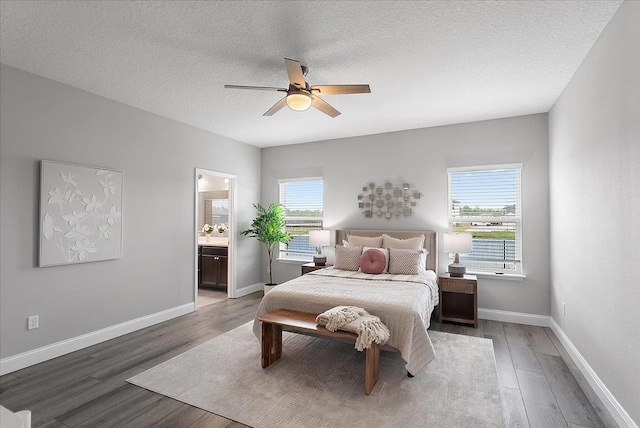 bedroom with light wood finished floors, multiple windows, a textured ceiling, and baseboards