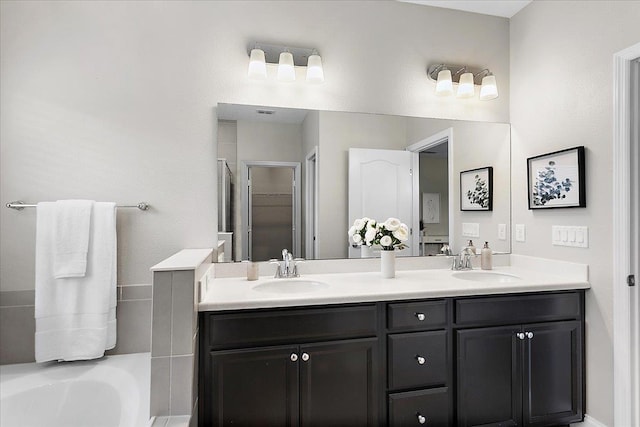 bathroom featuring double vanity, a bath, and a sink