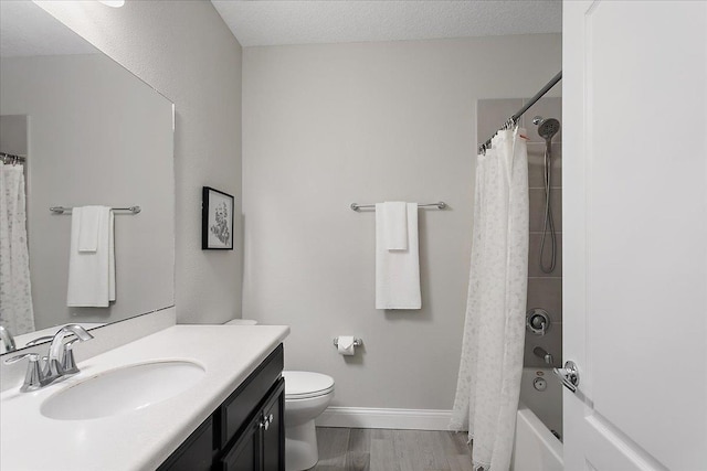 bathroom with baseboards, toilet, vanity, wood finished floors, and a textured ceiling