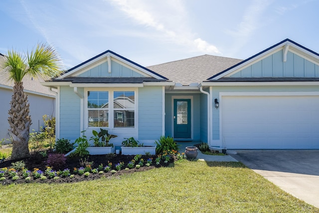 135 Sunstone Ct, Saint Augustine, FL 32086 - view of front of property featuring board and batten siding, a front lawn, driveway, a garage, and a shingled roof