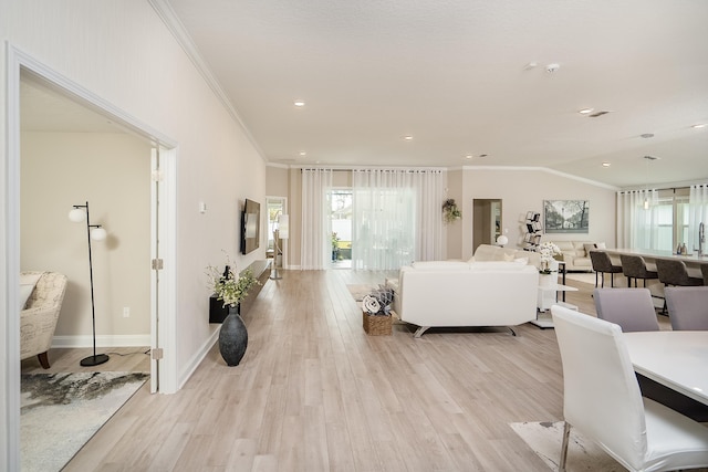 living area with crown molding, light wood finished floors, recessed lighting, vaulted ceiling, and baseboards