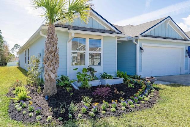 view of front of property featuring an attached garage, a shingled roof, driveway, board and batten siding, and a front yard