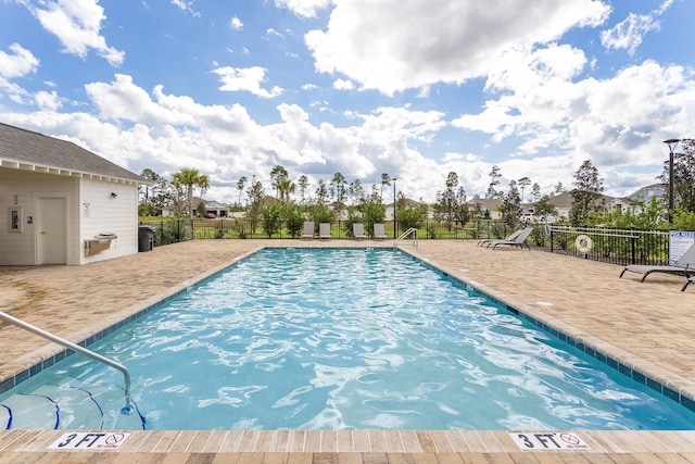 community pool featuring fence and a patio