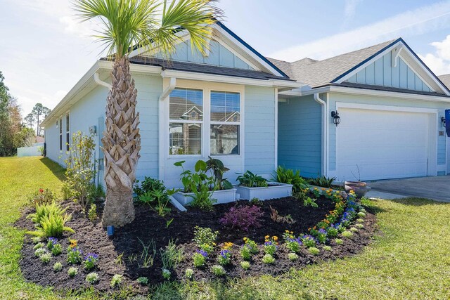 135 Sunstone Ct, Saint Augustine, FL 32086 - view of front of house featuring board and batten siding, an attached garage, a front yard, driveway, and a shingled roof