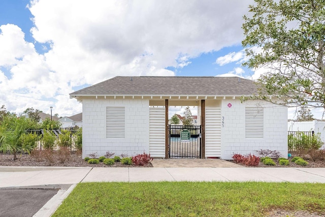 view of front of home featuring a shingled roof, a gate, and fence