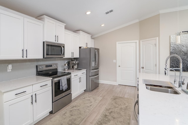 kitchen with crown molding, stainless steel appliances, tasteful backsplash, visible vents, and a sink