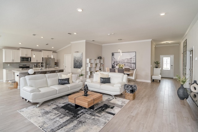 living room with ornamental molding, recessed lighting, light wood-style flooring, and baseboards