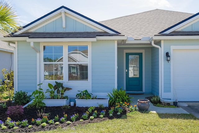 entrance to property with a garage, a shingled roof, and board and batten siding