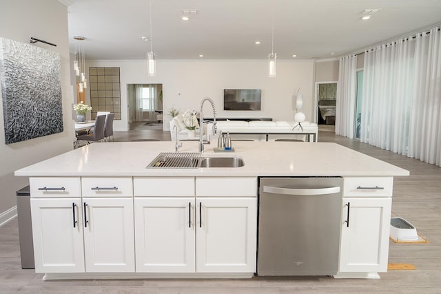 kitchen with dishwasher, light stone counters, open floor plan, white cabinetry, and a sink