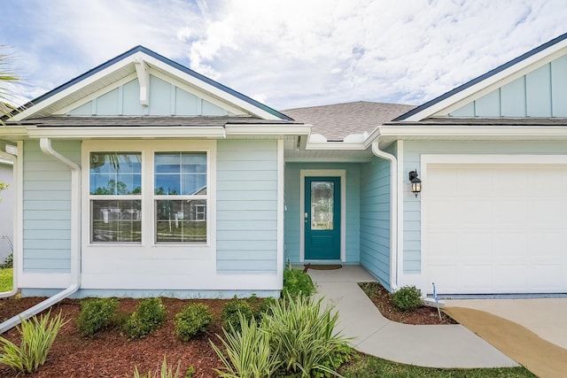 property entrance with an attached garage, board and batten siding, and roof with shingles