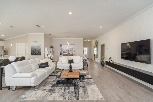 living area featuring ornamental molding, light wood finished floors, baseboards, and recessed lighting