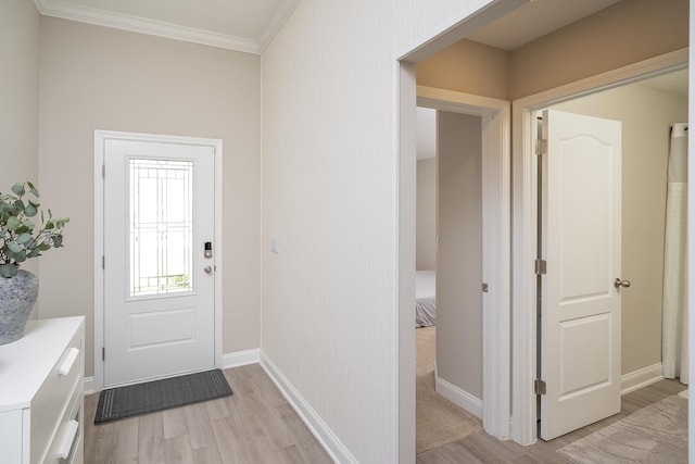 foyer featuring light wood-type flooring, crown molding, and baseboards