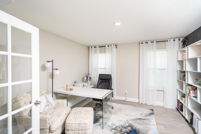 office space featuring baseboards, visible vents, wood finished floors, and french doors