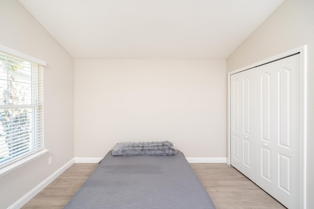 bedroom featuring light wood-style floors, a closet, and baseboards