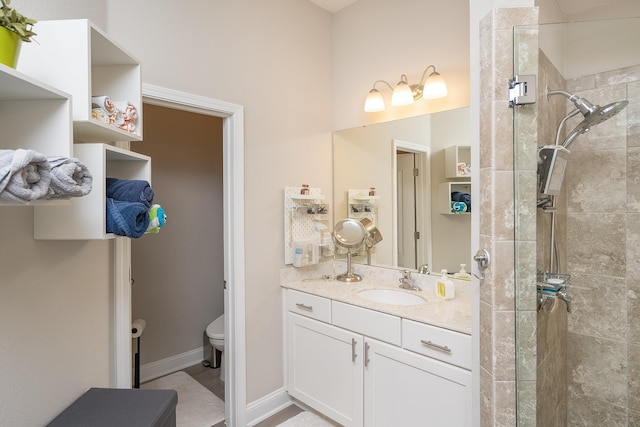 full bath featuring toilet, baseboards, a tile shower, and vanity