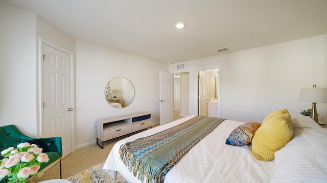 bedroom with light colored carpet and ensuite bathroom